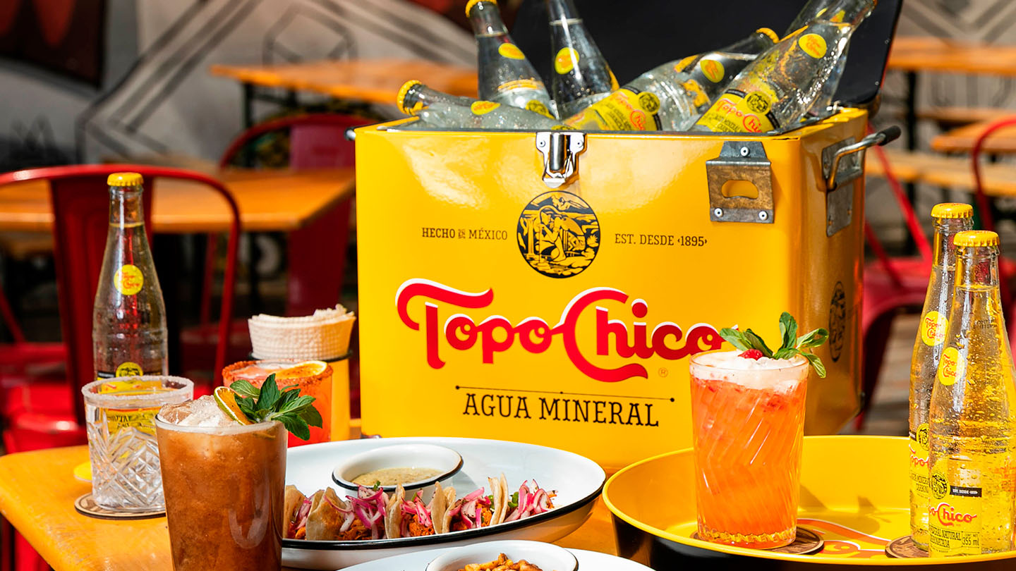 Presentacion de comida Gourmet con Topo Chico agua mineral.