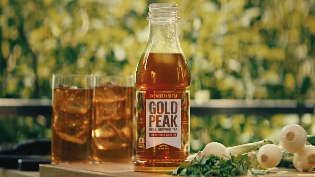 gold peak bottle with glasses of tea